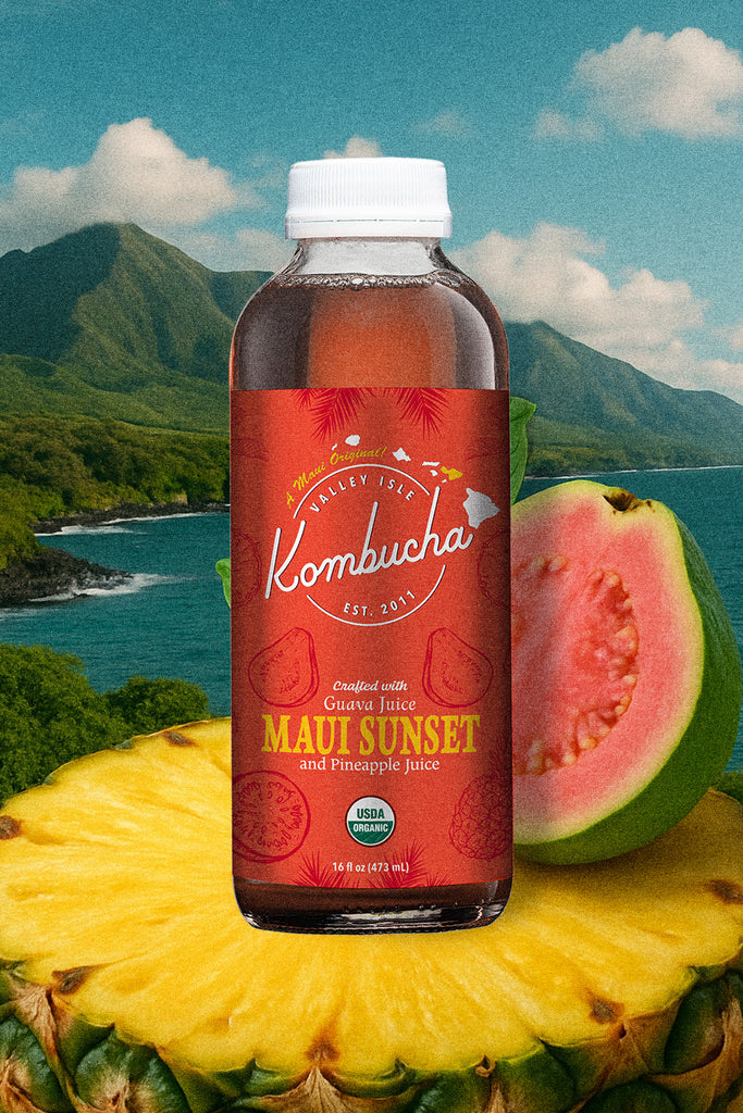 Bottle of Kombucha with Maui Sunset flavor on a scenic background with pineapple and guava.